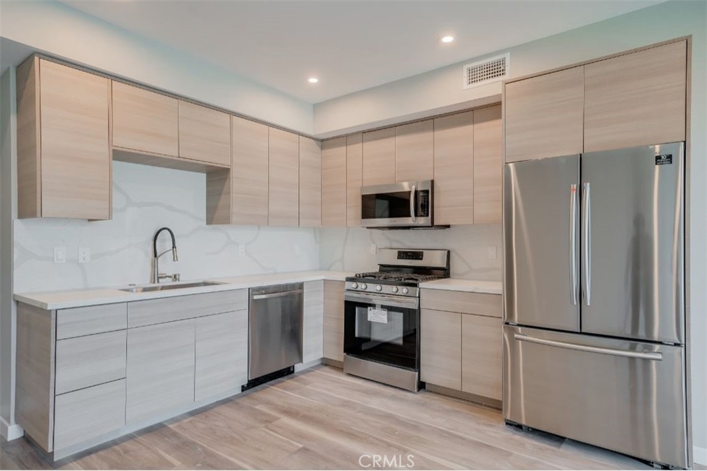 7018 Alabama Avenue, Unit 201 Canoga Park, CA 91303 - Photo 19 of 25 a kitchen with stainless steel appliances a refrigerator sink and cabinets