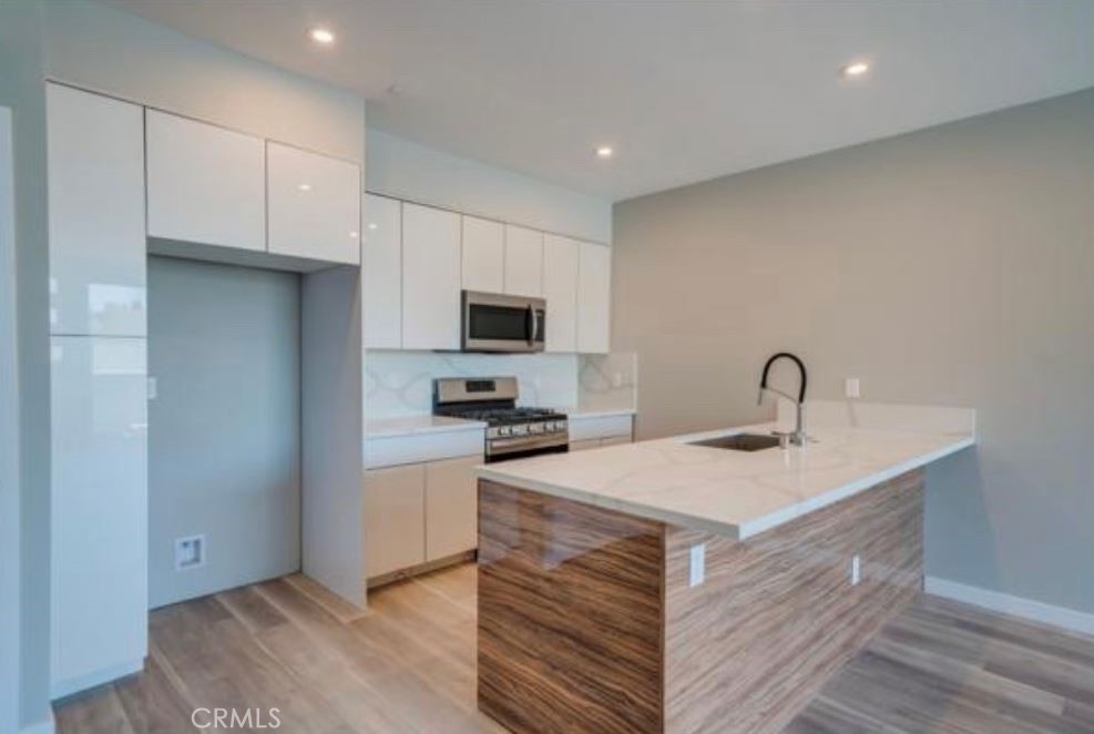 7018 Alabama Avenue, Unit 201 Canoga Park, CA 91303 - Photo 21 of 25 a kitchen with a sink a stove and cabinets