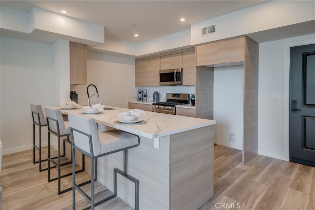7018 Alabama Avenue, Unit 201 Canoga Park, CA 91303 - Photo 23 of 25 a kitchen with a sink a microwave and cabinets
