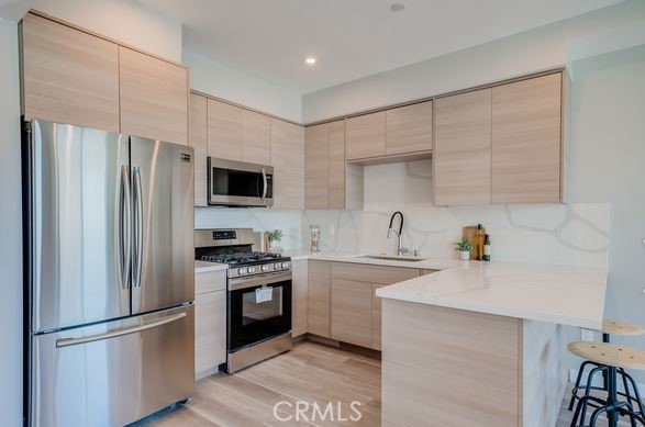 7018 Alabama Avenue, Unit 201 Canoga Park, CA 91303 - Photo 24 of 25 a kitchen with stainless steel appliances a refrigerator stove and sink