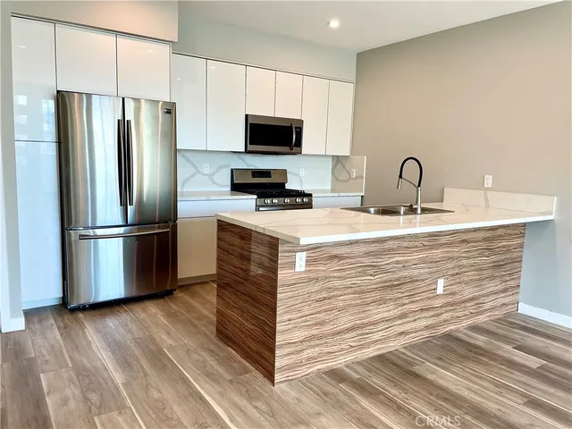 a kitchen with kitchen island granite countertop a stove a sink and a refrigerator