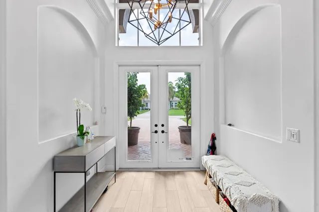a dining room with wooden floor and a chandelier