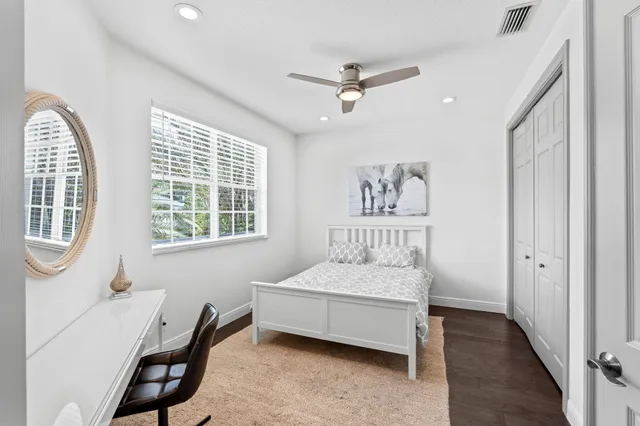 a bedroom with a bed a large window and flat screen television