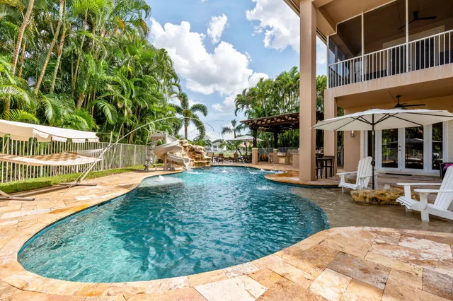 an aerial view of a house with a yard and pool