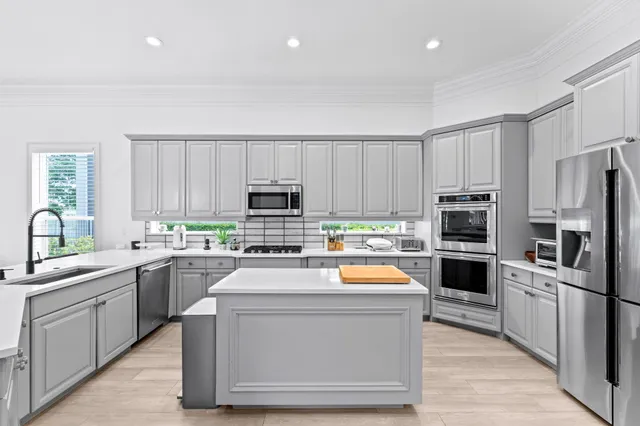 a kitchen with stainless steel appliances granite countertop a sink a stove and a microwave