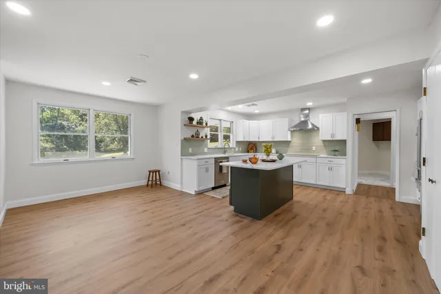 a large kitchen with wooden floors and stainless steel appliances