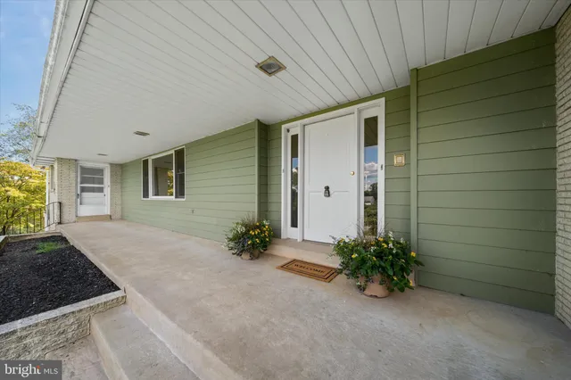 a view of a house with a potted plant ana a small yard