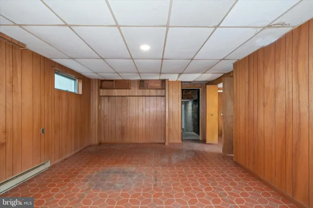 a view of a yard with plants and large trees