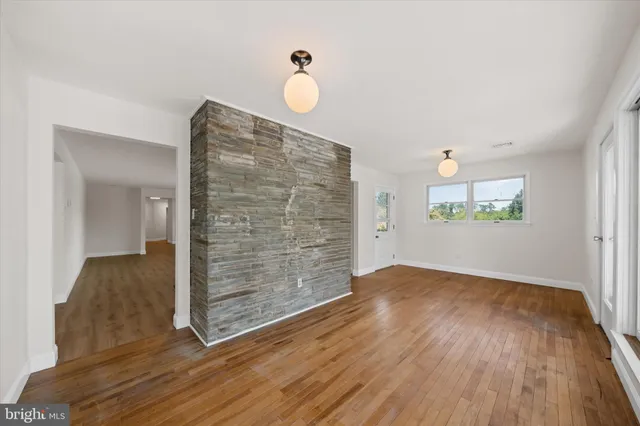 a view of a room with wooden floor and windows