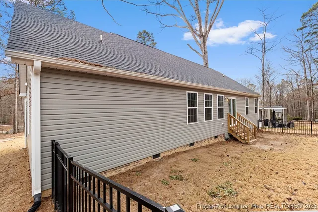 a view of a house with backyard and wooden fence