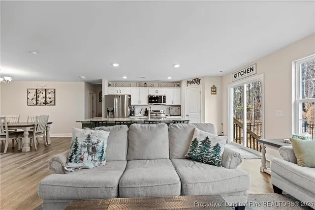 a large kitchen with kitchen island a dining table chairs stainless steel appliances and cabinets