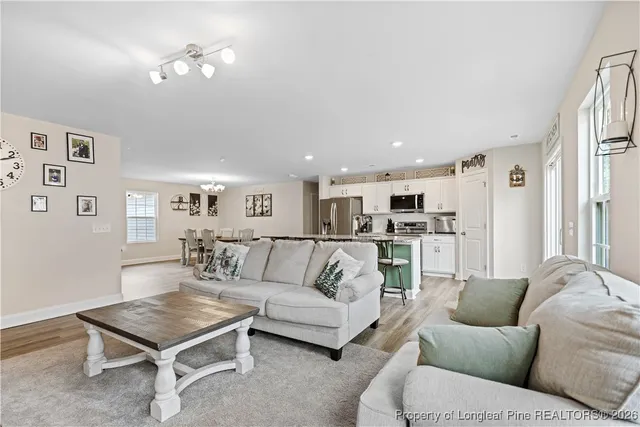 a living room with furniture and a dining table with kitchen view