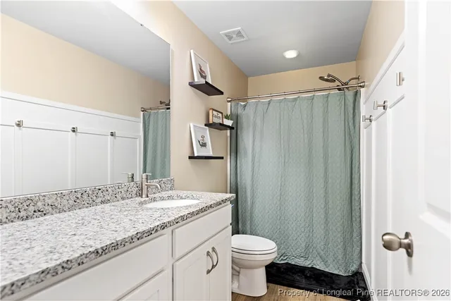 a bathroom with a granite countertop sink toilet and shower