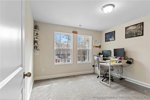 a view of a workspace with furniture and a window