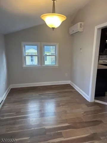 a room with wooden floor and a chandelier
