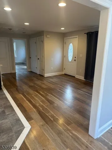 an empty room with wooden floor and window