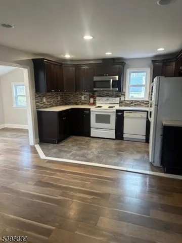 a large kitchen with a sink stainless steel appliances and cabinets