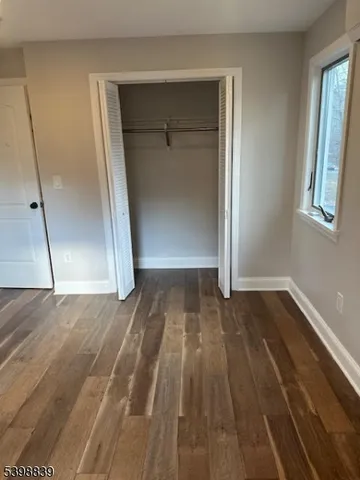 a view of a room with wooden floor and window