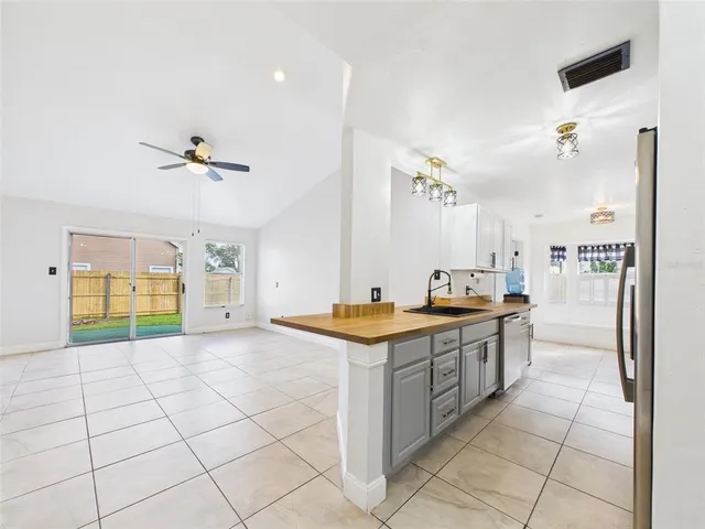 a kitchen with stainless steel appliances granite countertop a sink and a refrigerator