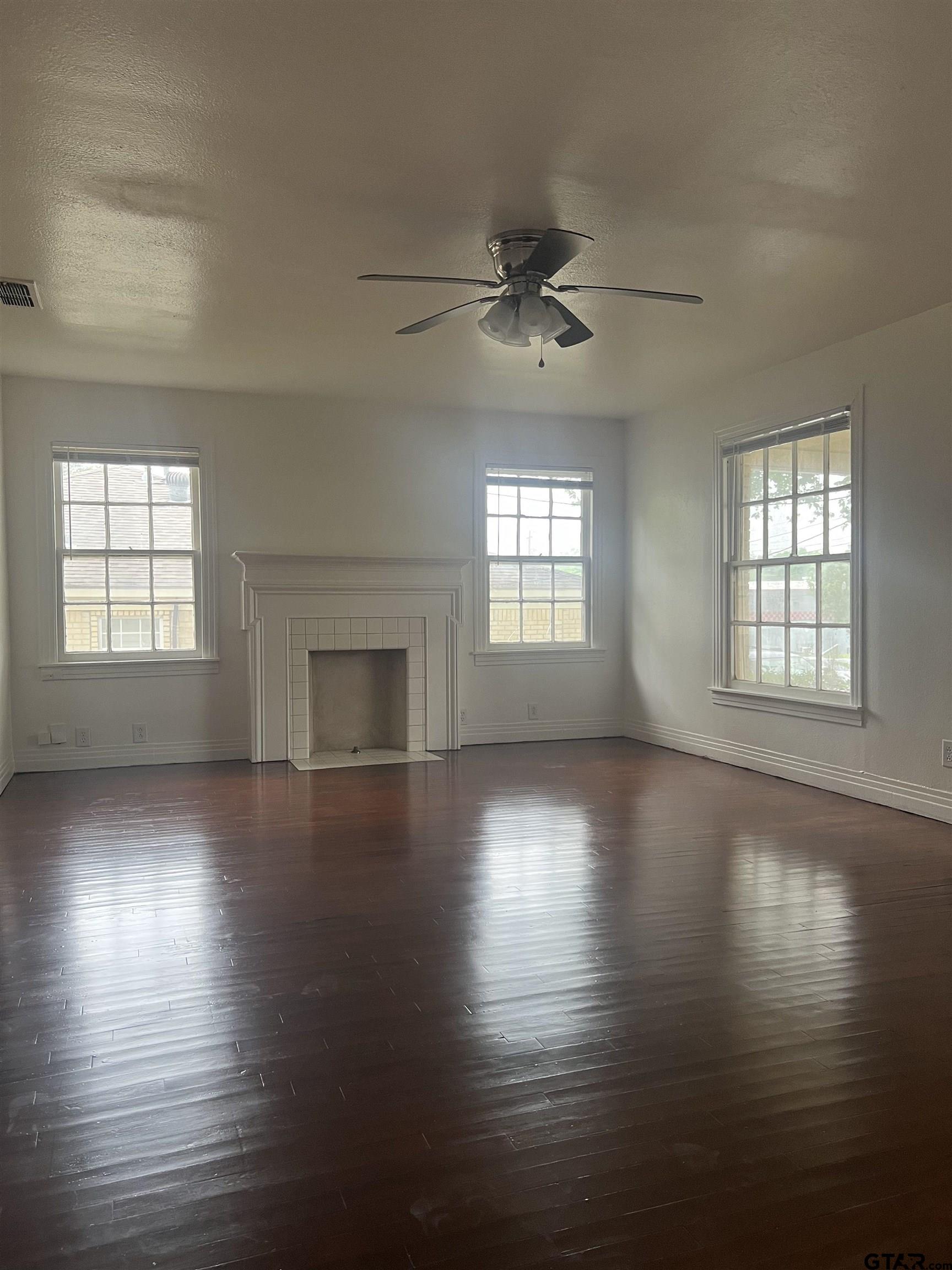 902 West 5th Street Tyler, TX 75701 - Photo 2 of 11 an empty room with wooden floor chandelier and windows