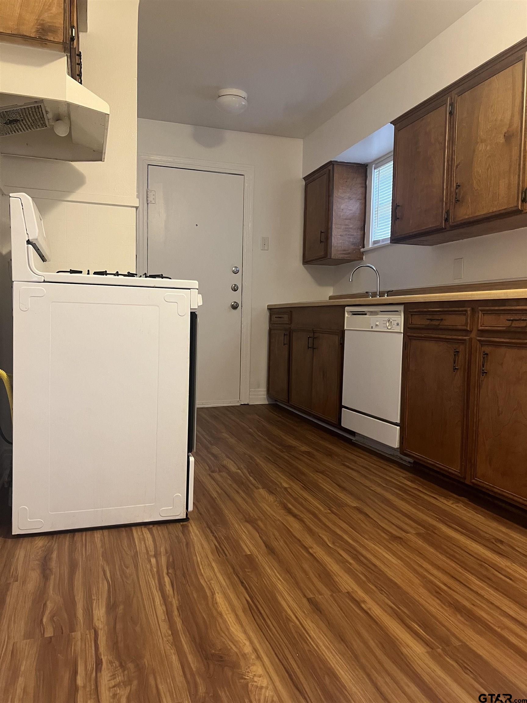902 West 5th Street Tyler, TX 75701 - Photo 3 of 11 a kitchen with granite countertop a stove a sink and a microwave