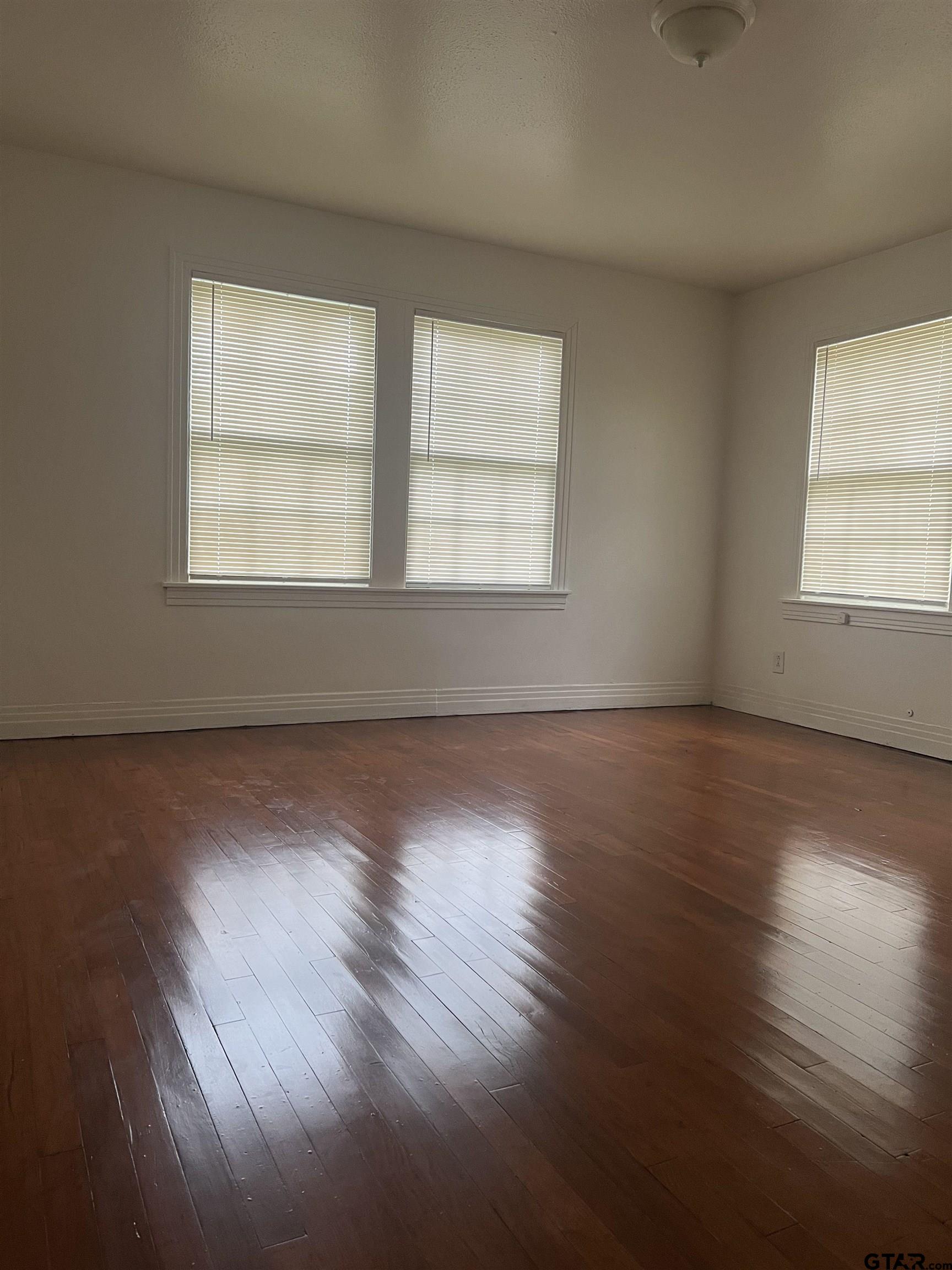 902 West 5th Street Tyler, TX 75701 - Photo 8 of 11 a view of an empty room with wooden floor and a window
