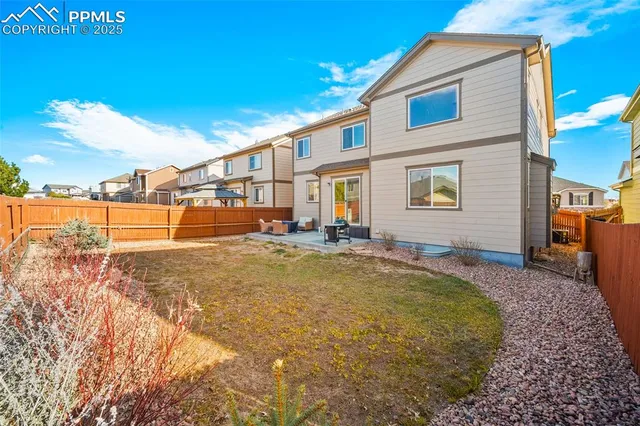 a view of a house with backyard and sitting area