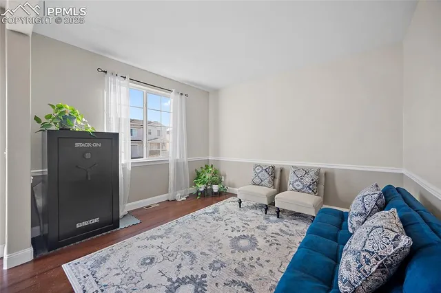 a living room with furniture and wooden floor