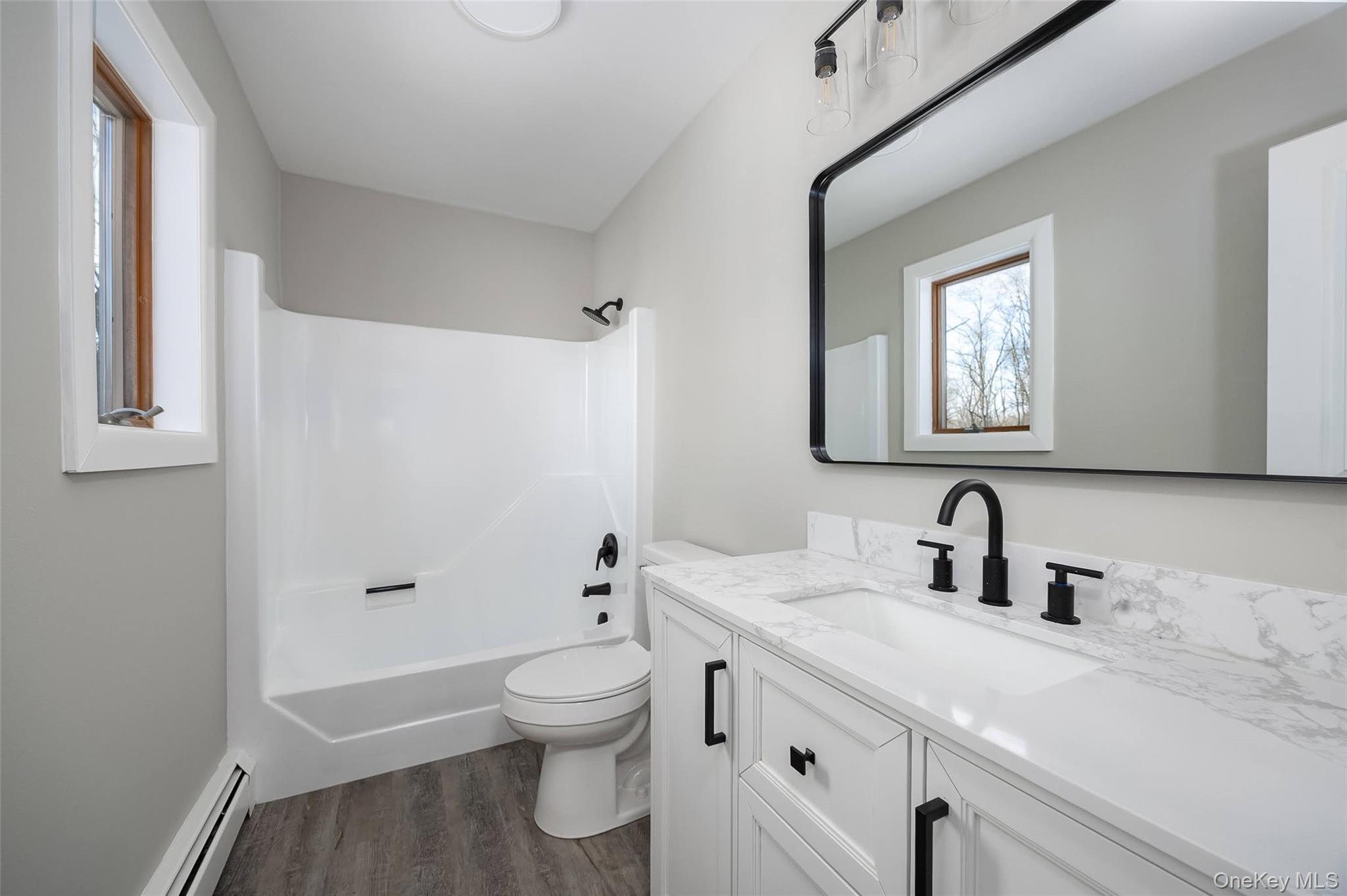 261 Freedom Road Pleasant Valley, NY 12569 - Photo 21 of 50 Full bath featuring vanity, a baseboard radiator, bathtub / shower combination, and dark wood finished floors