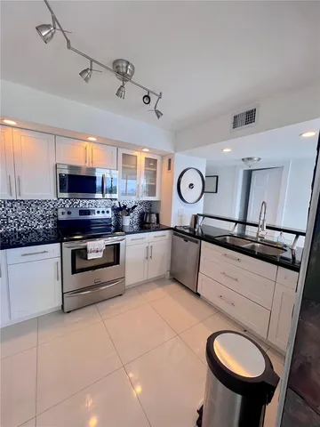 a kitchen with stainless steel appliances granite countertop a sink and cabinets