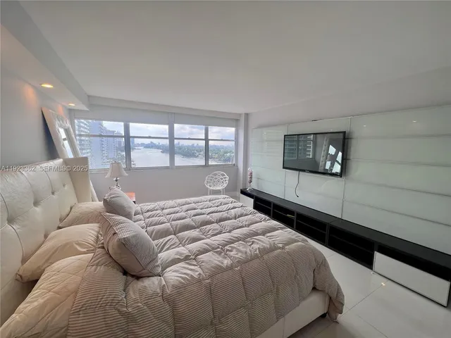 a bedroom with a large bed and a large window