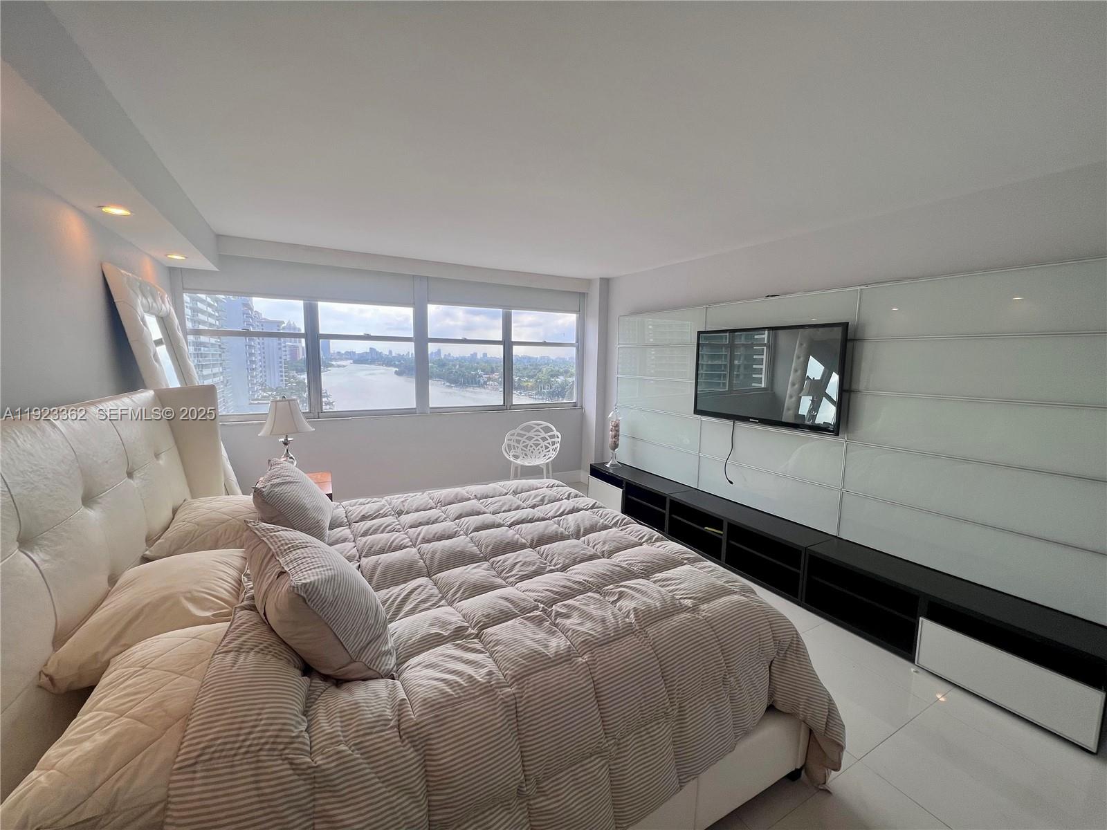 5838 Collins Avenue, Unit 8B Miami Beach, FL 33140 - Photo 14 of 30 a bedroom with a large bed and a large window