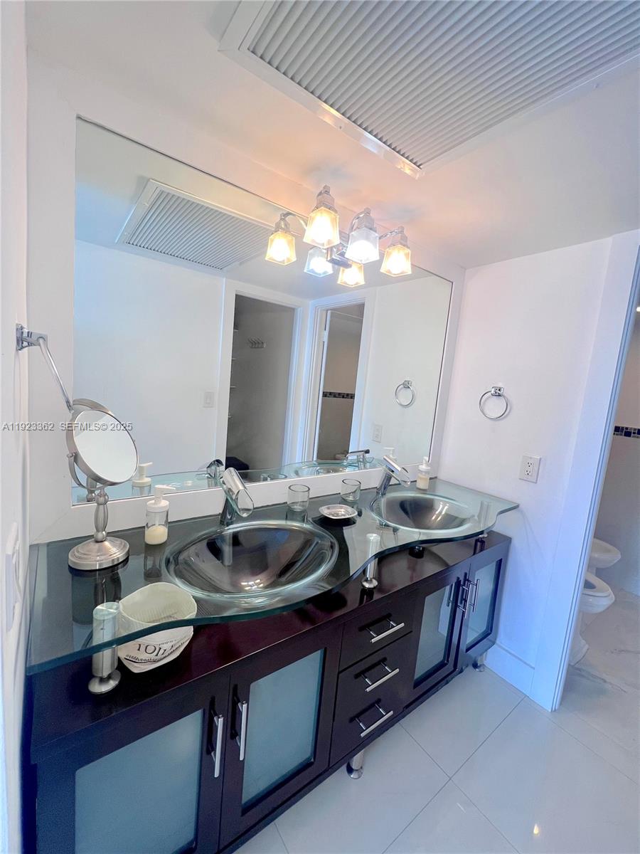 5838 Collins Avenue, Unit 8B Miami Beach, FL 33140 - Photo 15 of 30 a bathroom with a granite countertop sink and a mirror