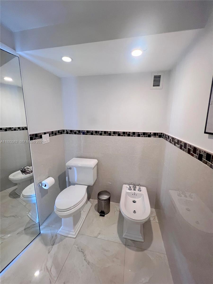 5838 Collins Avenue, Unit 8B Miami Beach, FL 33140 - Photo 16 of 30 a bathroom with a toilet a sink and a shower