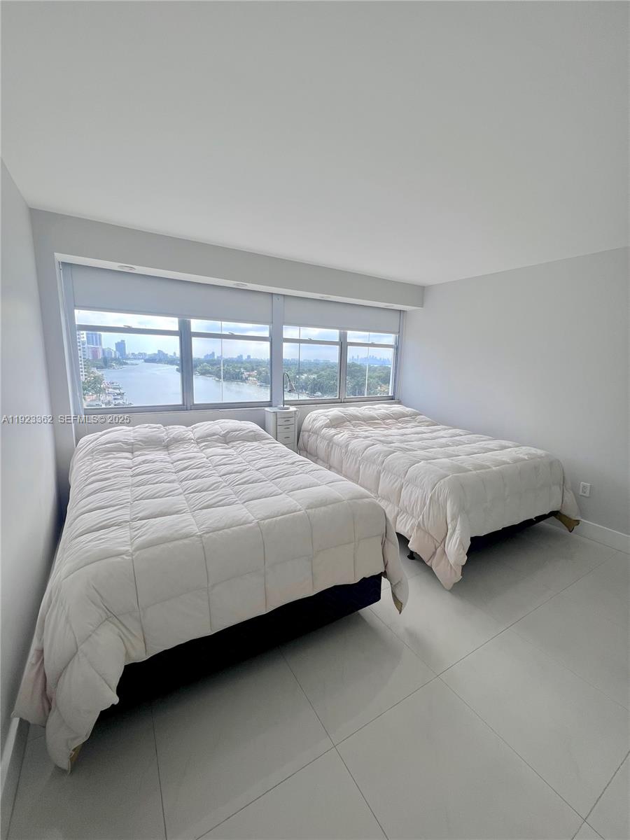 5838 Collins Avenue, Unit 8B Miami Beach, FL 33140 - Photo 18 of 30 a bedroom with two bed and a large window