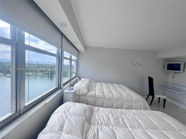 a bedroom with a large bed and a balcony view