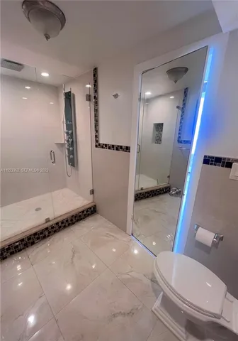 a bathroom with a granite countertop sink mirror vanity and toilet