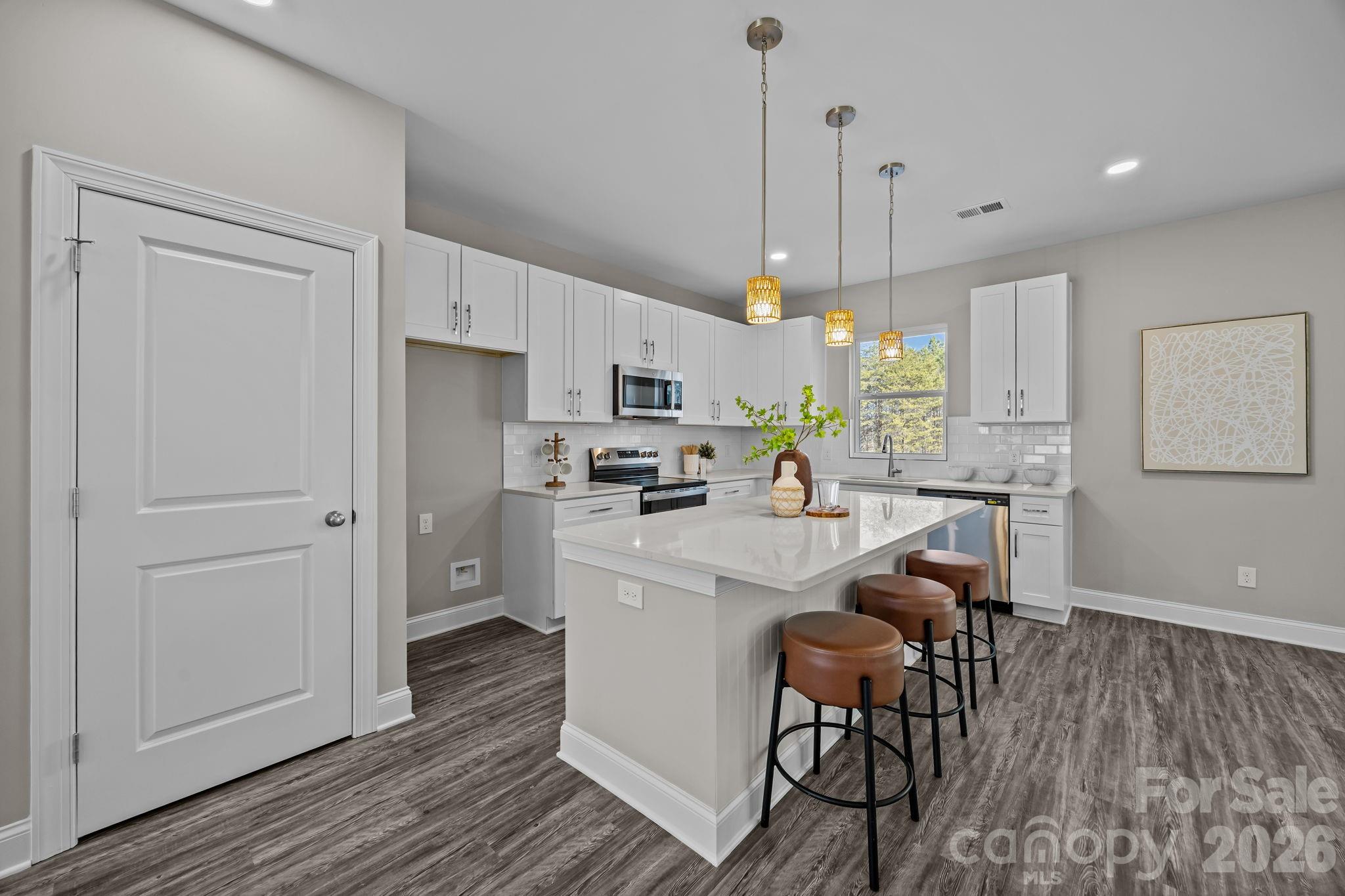 1813 Shuford Road Lincolnton, NC 28092 - Photo 11 of 47 a kitchen with stainless steel appliances a dining table chairs refrigerator and microwave