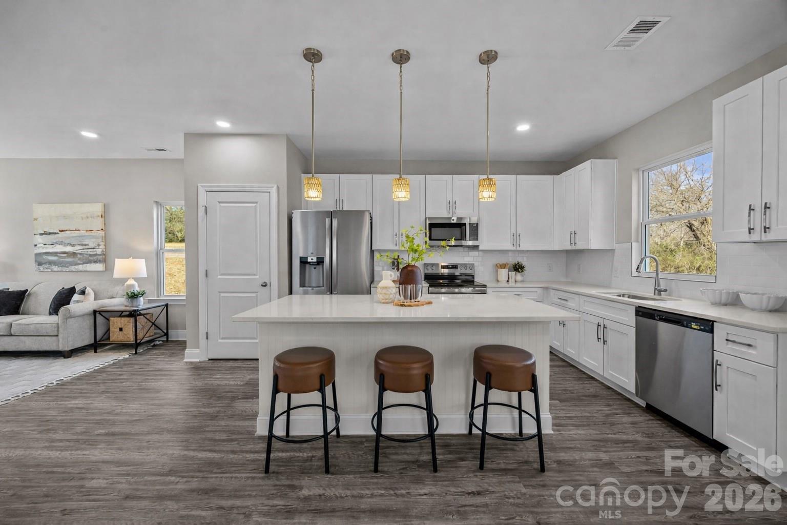 1813 Shuford Road Lincolnton, NC 28092 - Photo 12 of 47 a kitchen with cabinets a sink a center island and stainless steel appliances