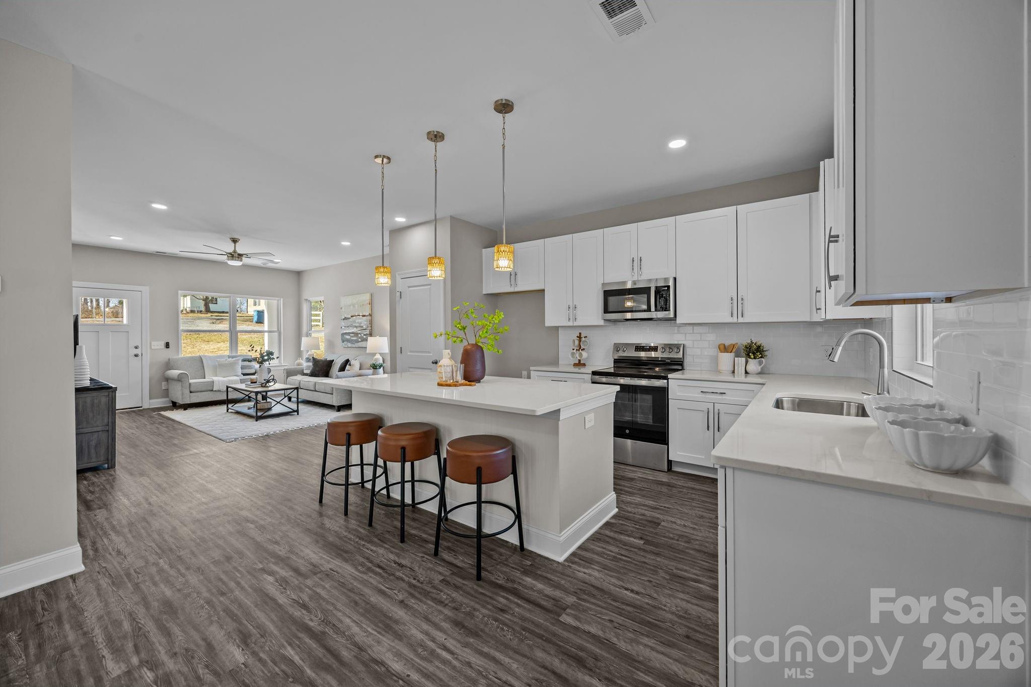1813 Shuford Road Lincolnton, NC 28092 - Photo 13 of 47 a kitchen with stove a sink and white cabinets with wooden floor