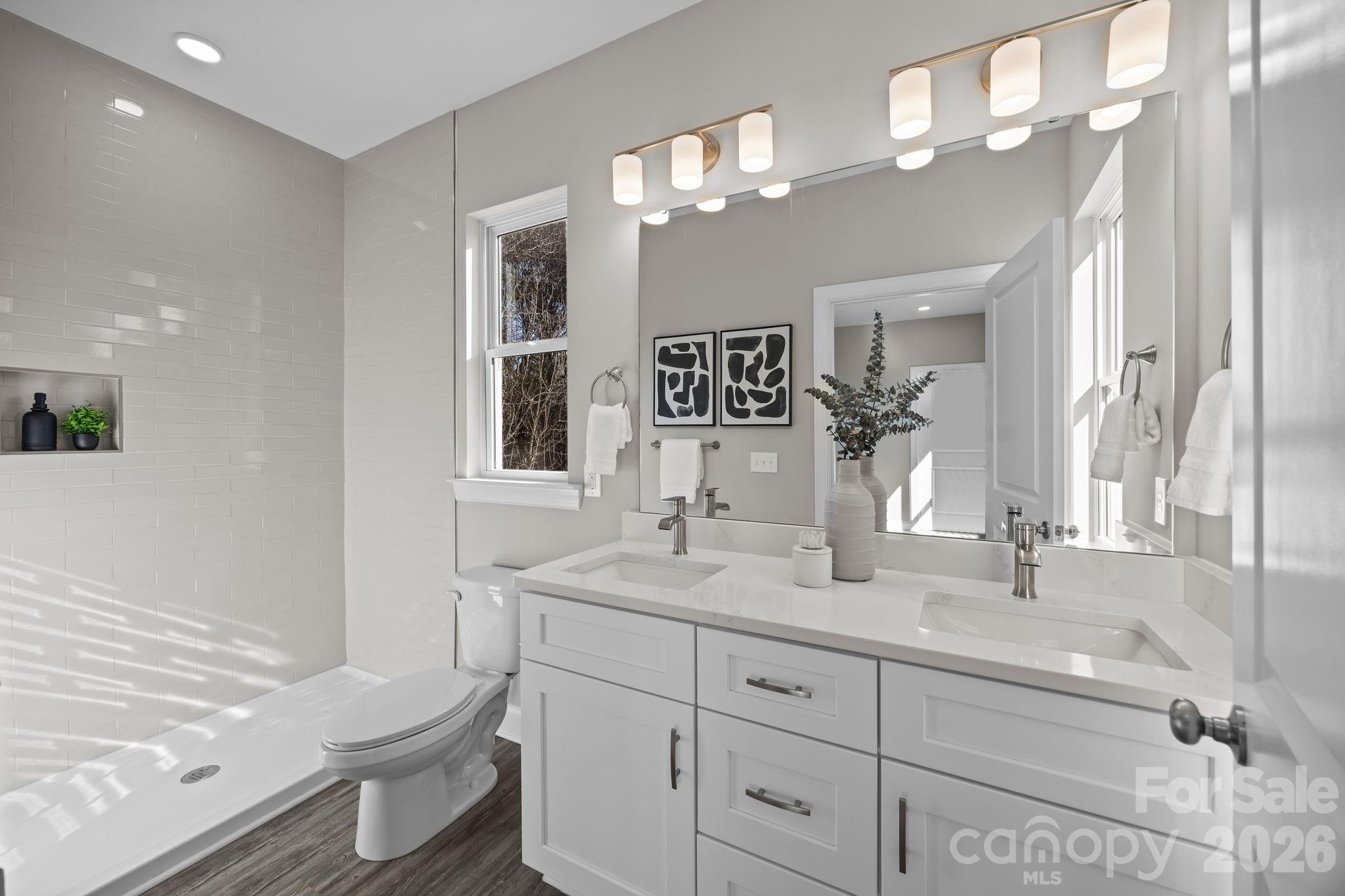 1813 Shuford Road Lincolnton, NC 28092 - Photo 26 of 47 a bathroom with a toilet a double vanity sink and a mirror