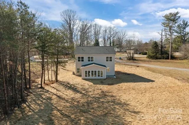 a view of a yard with plants and a brick wall