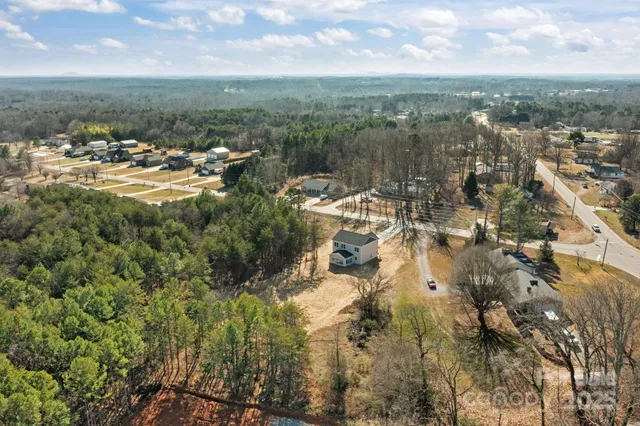 a white house with a big yard and large trees
