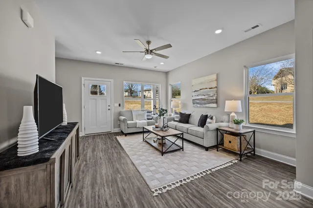 a living room with furniture a window and a flat screen tv