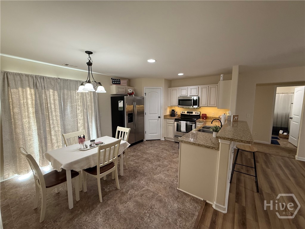 102 Black Pine Drive Springfield, GA 31329 - Photo 11 of 13 Kitchen with a large corner pantry, eat at bar top, open floor plan with sliding glass door opening to the grilling patio out back.