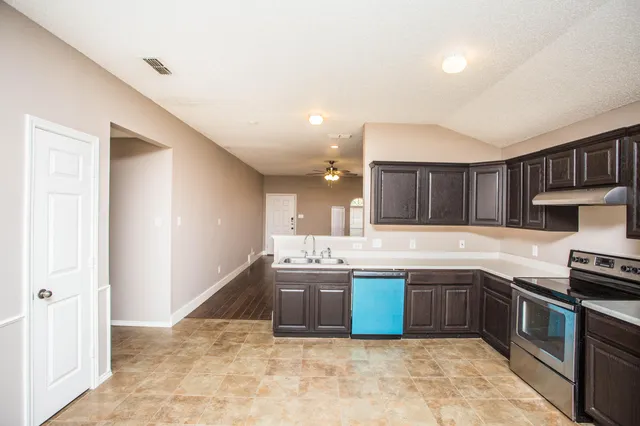 a large kitchen with cabinets and stainless steel appliances