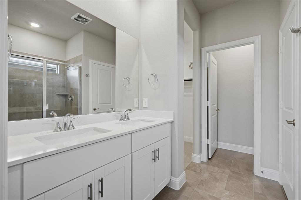 1701 Arches Road Anna, TX 75409 - Photo 14 of 19 Dual vanity with white cabinetry, polished chrome fixtures, and a large integrated mirror