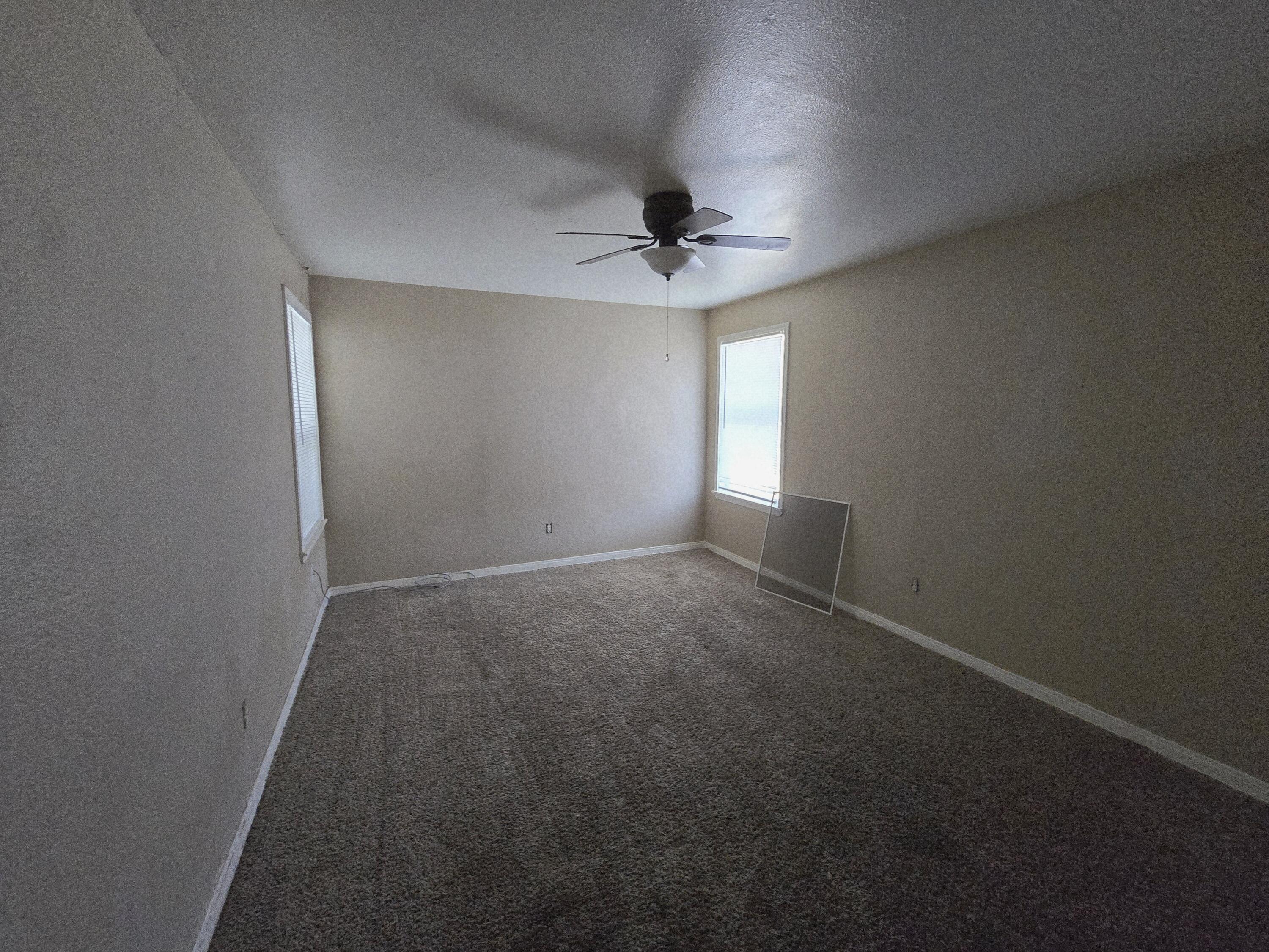 1011 Wayland Plainview, TX 79072 - Photo 11 of 14 an empty room with windows and fan