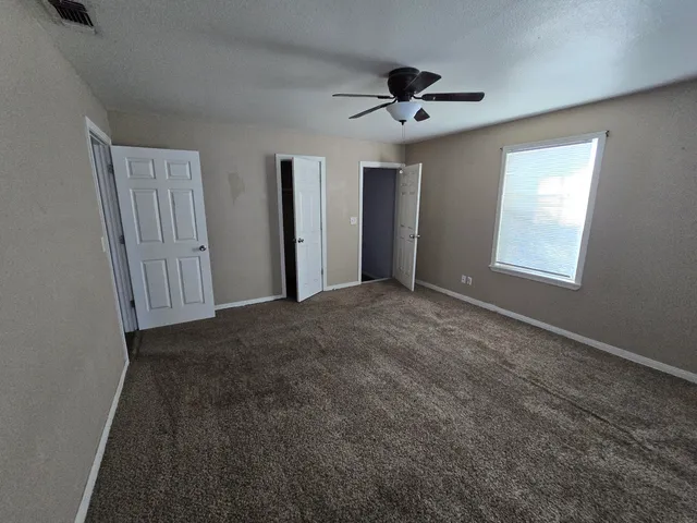 a view of an empty room with a ceiling fan