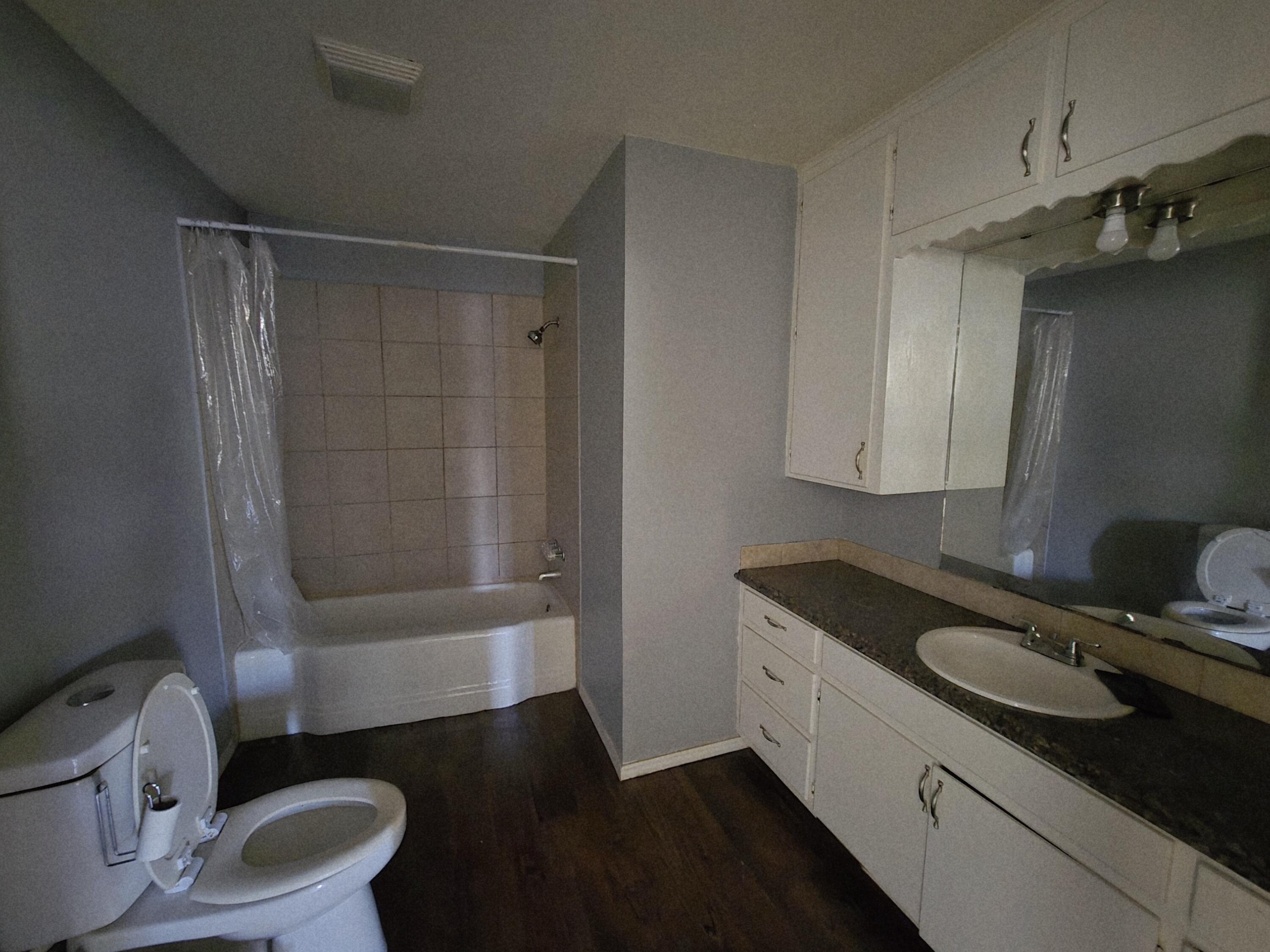 1011 Wayland Plainview, TX 79072 - Photo 14 of 14 a bathroom with a granite countertop sink toilet and shower